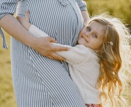 Pregnant mother with her daughter in a field